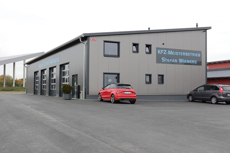 Werkstatthalle bauen für Kfz-Werkstatt, seitliche Außenansicht, Sektionaltore, Bürotrakt