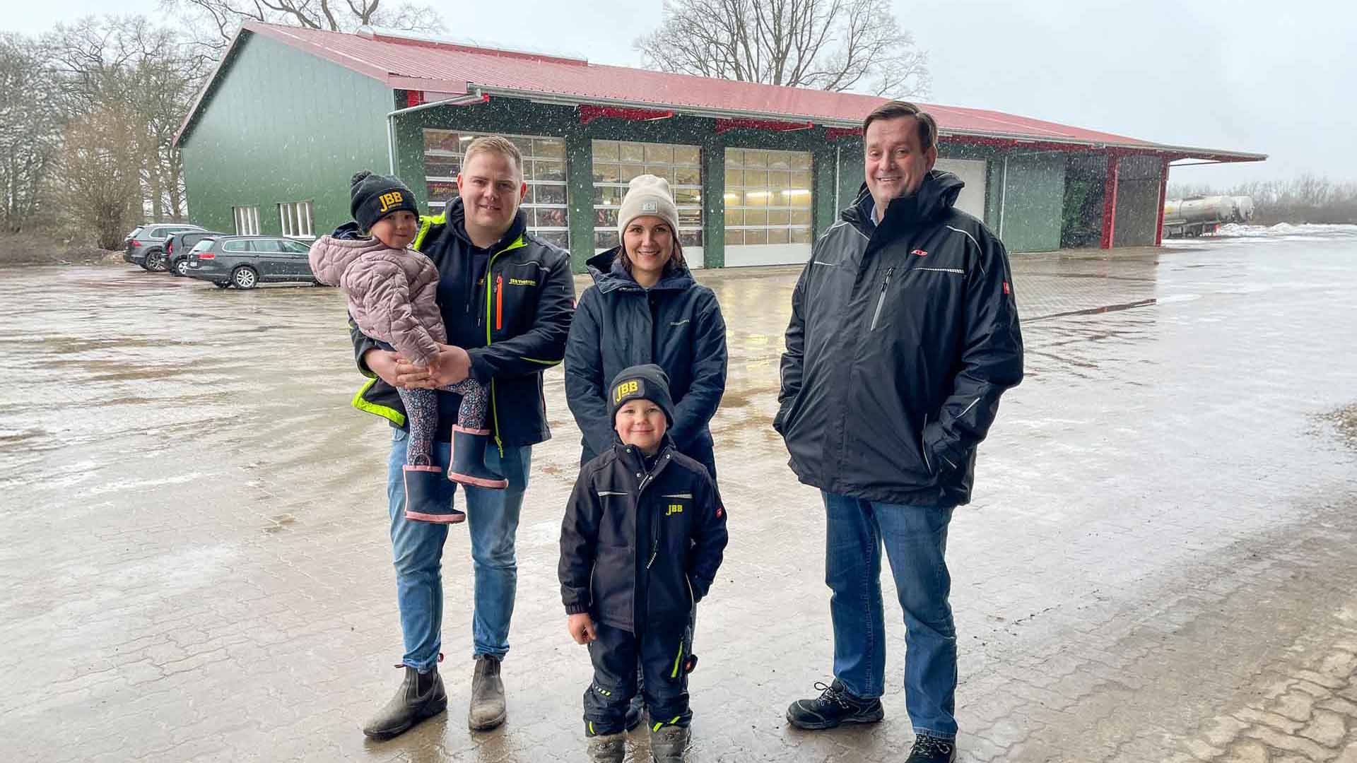 Familie Bromann-Behrens (v. l.: Johanna, Julian, Jennifer und Jonne) mit Kai Rathing (r.) vor der neuen Werkstatthalle.